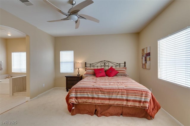 10243 Songsparrow Ct, Las Vegas, NV 89135 - bedroom featuring arched walkways, light colored carpet, connected bathroom, and a ceiling fan
