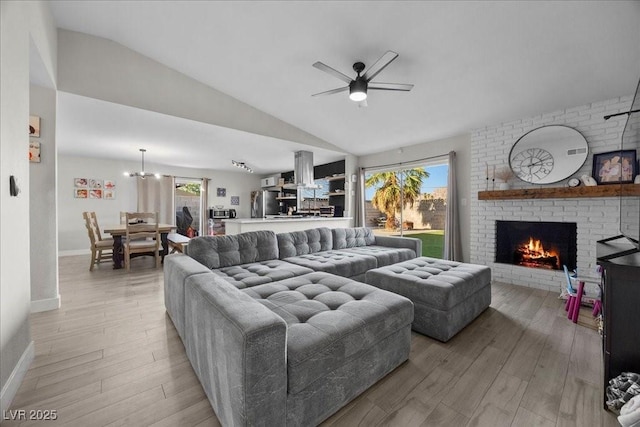 2088 Miner Way, Las Vegas, NV 89104 - living room featuring a ceiling fan, a brick fireplace, light wood-type flooring, lofted ceiling, and a chandelier