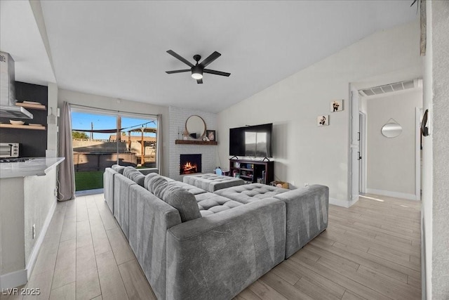 2088 Miner Way, Las Vegas, NV 89104 - living room with a ceiling fan, lofted ceiling, light wood-style floors, and a fireplace