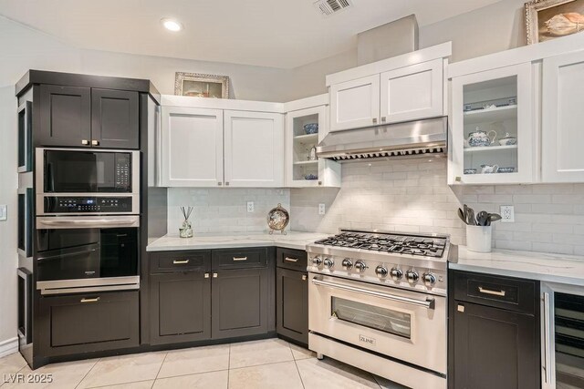 3111 Lido Isle Ct, Las Vegas, NV 89117 - kitchen featuring stainless steel appliances, under cabinet range hood, wine cooler, white cabinetry, and decorative backsplash