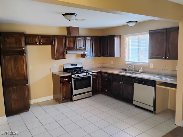 608 Watkins Dr, Las Vegas, NV 89107 - kitchen featuring gas range, dishwasher, under cabinet range hood, light countertops, and dark brown cabinetry