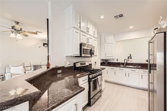 2050 W Warm Springs Rd Unit 3624, Henderson, NV 89014 - kitchen featuring stainless steel appliances, ceiling fan, white cabinetry, dark stone countertops, and recessed lighting