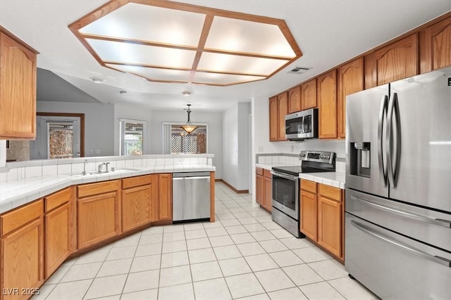 5981 Doubletree Rd, Pahrump, NV 89061 - kitchen featuring stainless steel appliances, tile countertops, light tile patterned flooring, and a peninsula