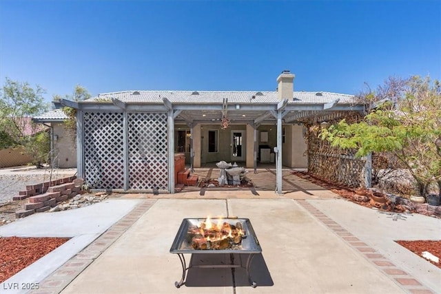 5981 Doubletree Rd, Pahrump, NV 89061 - rear view of house featuring an outdoor fire pit, a patio, a chimney, and a pergola