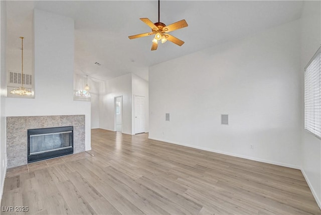 641 Bay Bridge Dr, North Las Vegas, NV 89032 - unfurnished living room with high vaulted ceiling, ceiling fan, light wood finished floors, and a tiled fireplace