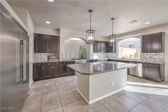 9876 Parador Cellars Ct, Las Vegas, NV 89141 - kitchen featuring stainless steel appliances, backsplash, dark brown cabinets, light tile patterned floors, and recessed lighting