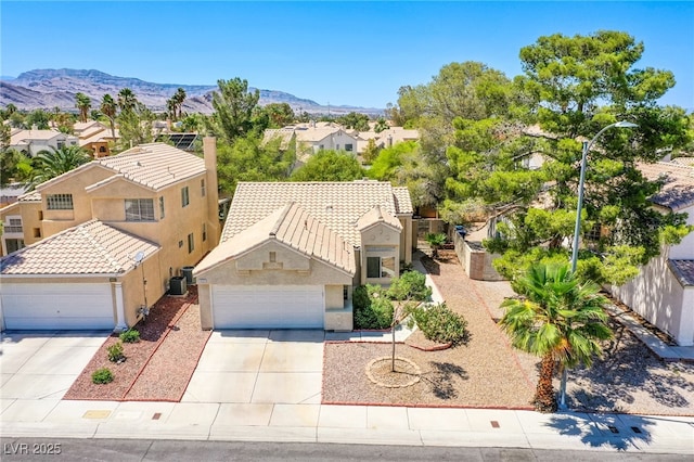 8324 Tide Pool Dr, Las Vegas, NV 89128 - view of front of house with a residential view, an attached garage, concrete driveway, and a mountain view