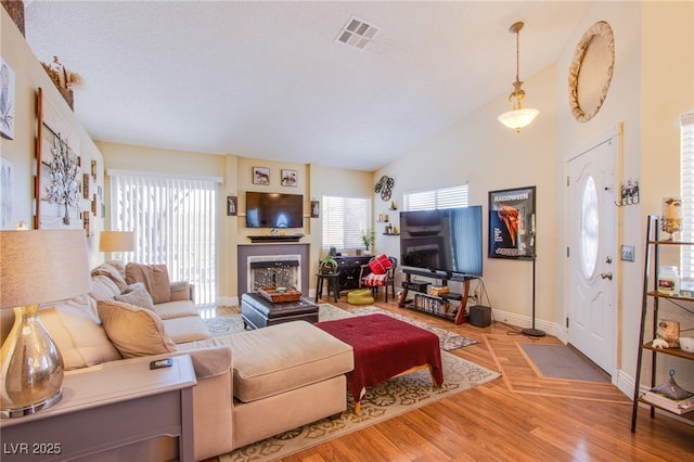 8324 Tide Pool Dr, Las Vegas, NV 89128 - living room with a fireplace, plenty of natural light, wood finished floors, and vaulted ceiling