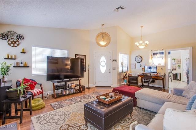 8324 Tide Pool Dr, Las Vegas, NV 89128 - living area featuring vaulted ceiling, a chandelier, and light wood-style floors