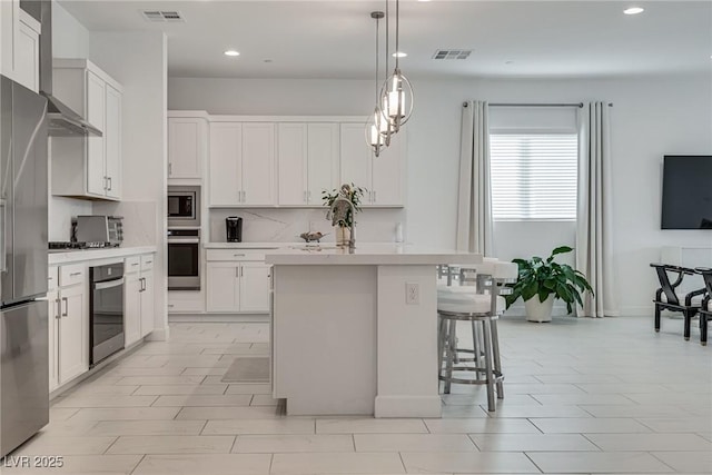 827 Klamath Springs St, Henderson, NV 89011 - kitchen with stainless steel appliances, recessed lighting, light countertops, tasteful backsplash, and a kitchen bar