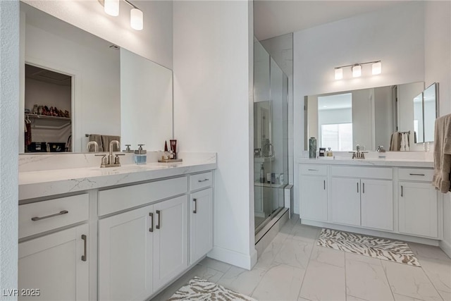 827 Klamath Springs St, Henderson, NV 89011 - bathroom featuring a shower stall, marble finish flooring, a walk in closet, and two vanities
