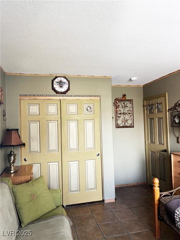 5929 Gentle Creek Ln, North Las Vegas, NV 89031 - living area featuring dark tile patterned flooring, a textured ceiling, and crown molding