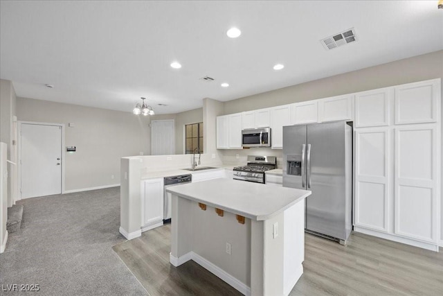 6460 Raven Hall St, North Las Vegas, NV 89084 - kitchen with stainless steel appliances, white cabinetry, a peninsula, light countertops, and recessed lighting