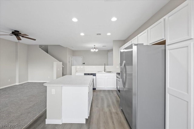 6460 Raven Hall St, North Las Vegas, NV 89084 - kitchen featuring appliances with stainless steel finishes, a center island, white cabinetry, ceiling fan, and open floor plan