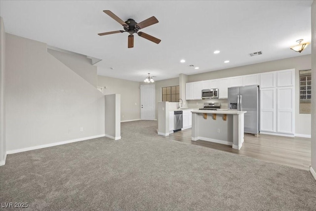 6460 Raven Hall St, North Las Vegas, NV 89084 - unfurnished living room featuring light colored carpet, ceiling fan, recessed lighting, and a chandelier