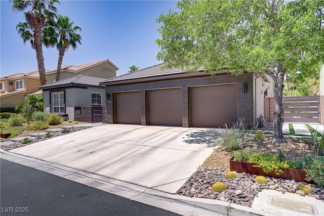 1509 Winslow St, Las Vegas, NV 89117 - view of front of house featuring driveway, an attached garage, stucco siding, and a tile roof