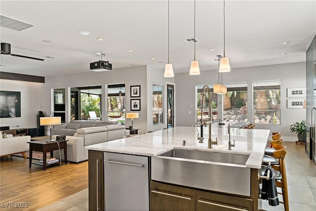 1509 Winslow St, Las Vegas, NV 89117 - kitchen with recessed lighting, a kitchen island with sink, light stone countertops, open floor plan, and decorative light fixtures
