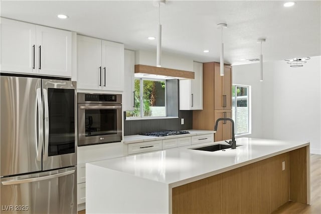 2105 Madagascar Ln, Las Vegas, NV 89117 - kitchen with appliances with stainless steel finishes, light countertops, white cabinetry, a kitchen island with sink, and recessed lighting