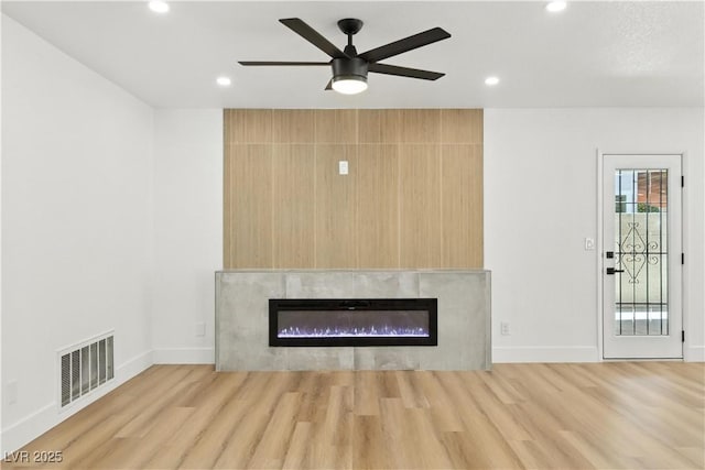 2105 Madagascar Ln, Las Vegas, NV 89117 - unfurnished living room featuring a glass covered fireplace, light wood-style floors, recessed lighting, and a ceiling fan