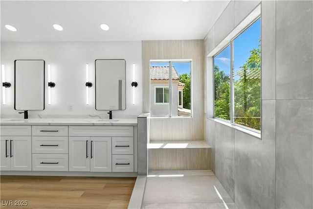 2105 Madagascar Ln, Las Vegas, NV 89117 - full bathroom featuring double vanity, plenty of natural light, recessed lighting, a tub to relax in, and wood finished floors