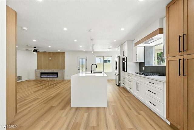 2105 Madagascar Ln, Las Vegas, NV 89117 - kitchen featuring recessed lighting, freestanding refrigerator, ceiling fan, light wood finished floors, and a glass covered fireplace