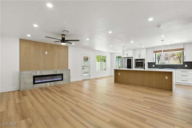 2105 Madagascar Ln, Las Vegas, NV 89117 - kitchen featuring stainless steel appliances, open floor plan, recessed lighting, white cabinetry, and healthy amount of natural light