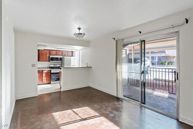 5200 Indian River Dr Unit 301, Las Vegas, NV 89103 - kitchen featuring stainless steel appliances, brown cabinetry, wood finished floors, and light countertops