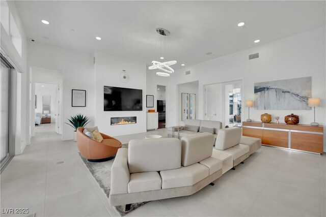 818 Calluna St, Las Vegas, NV 89138 - living area featuring a chandelier, a high ceiling, recessed lighting, a glass covered fireplace, and light tile patterned floors