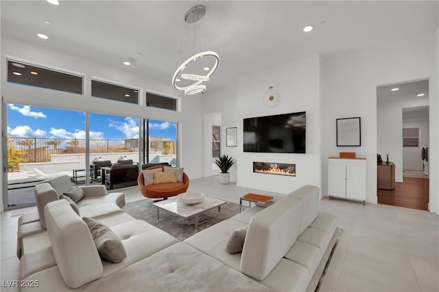 818 Calluna St, Las Vegas, NV 89138 - living area featuring a high ceiling, recessed lighting, a chandelier, and a glass covered fireplace