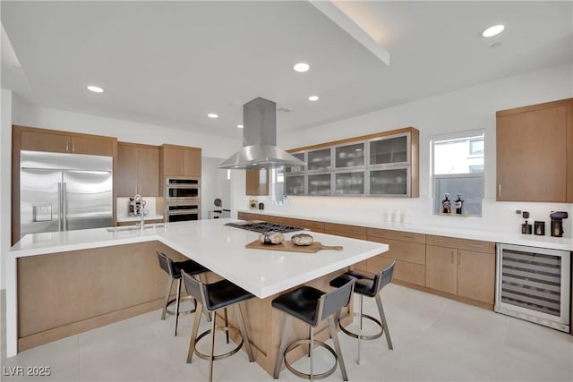 818 Calluna St, Las Vegas, NV 89138 - kitchen featuring wine cooler, appliances with stainless steel finishes, island range hood, a breakfast bar, and glass insert cabinets