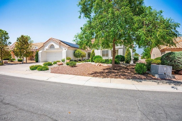 9704 Brawley Dr, Las Vegas, NV 89134 - obstructed view of property with roof mounted solar panels, a garage, concrete driveway, stucco siding, and a tiled roof