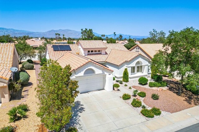 9704 Brawley Dr, Las Vegas, NV 89134 - mediterranean / spanish house with a tiled roof, driveway, a garage, a mountain view, and stucco siding