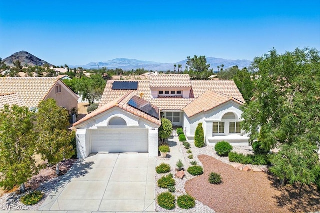 9704 Brawley Dr, Las Vegas, NV 89134 - mediterranean / spanish house with a tile roof, driveway, a garage, roof mounted solar panels, and stucco siding