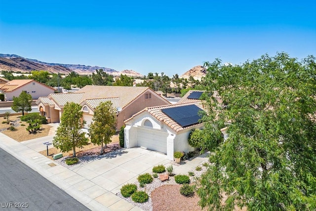 9704 Brawley Dr, Las Vegas, NV 89134 - mediterranean / spanish home featuring a garage, a tiled roof, driveway, roof mounted solar panels, and stucco siding