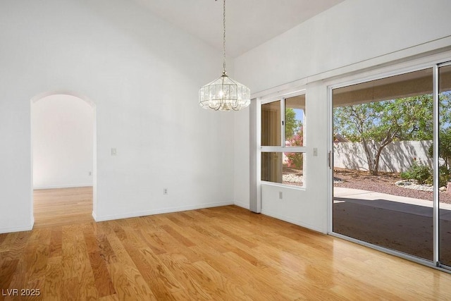 9704 Brawley Dr, Las Vegas, NV 89134 - spare room with wood finished floors, arched walkways, a chandelier, and high vaulted ceiling