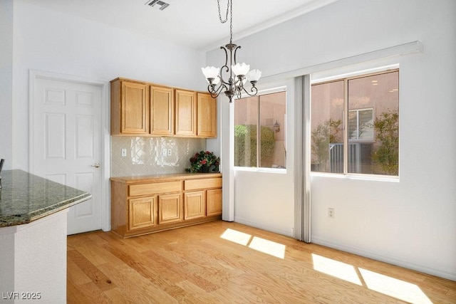 9704 Brawley Dr, Las Vegas, NV 89134 - kitchen with light wood-style flooring, a chandelier, backsplash, and decorative light fixtures