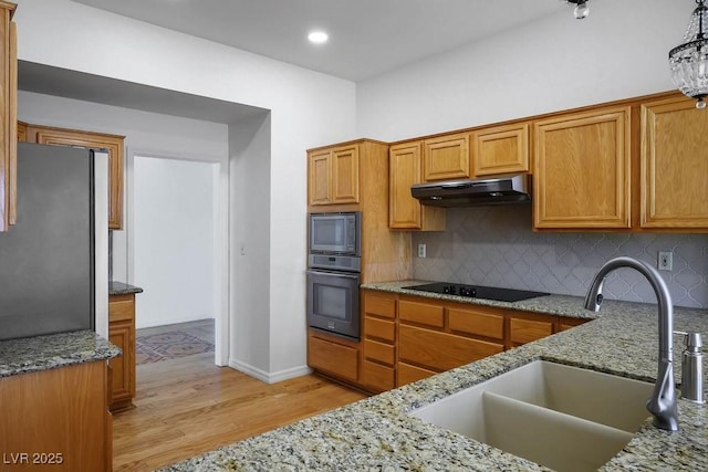 9704 Brawley Dr, Las Vegas, NV 89134 - kitchen with appliances with stainless steel finishes, extractor fan, light wood-style floors, light stone countertops, and tasteful backsplash
