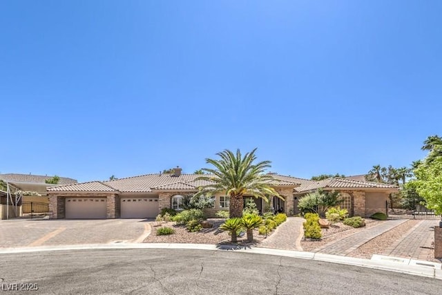 9135 Hickam Ave, Las Vegas, NV 89129 - view of front of house featuring a tiled roof, a garage, asphalt driveway, stucco siding, and stone siding