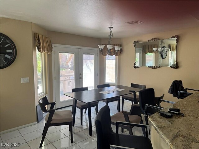 8225 Bermuda Beach Dr, Las Vegas, NV 89128 - dining area with a chandelier, healthy amount of natural light, light tile patterned flooring, and french doors