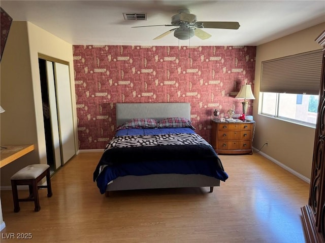 8225 Bermuda Beach Dr, Las Vegas, NV 89128 - bedroom with an accent wall, light wood-style floors, and a ceiling fan
