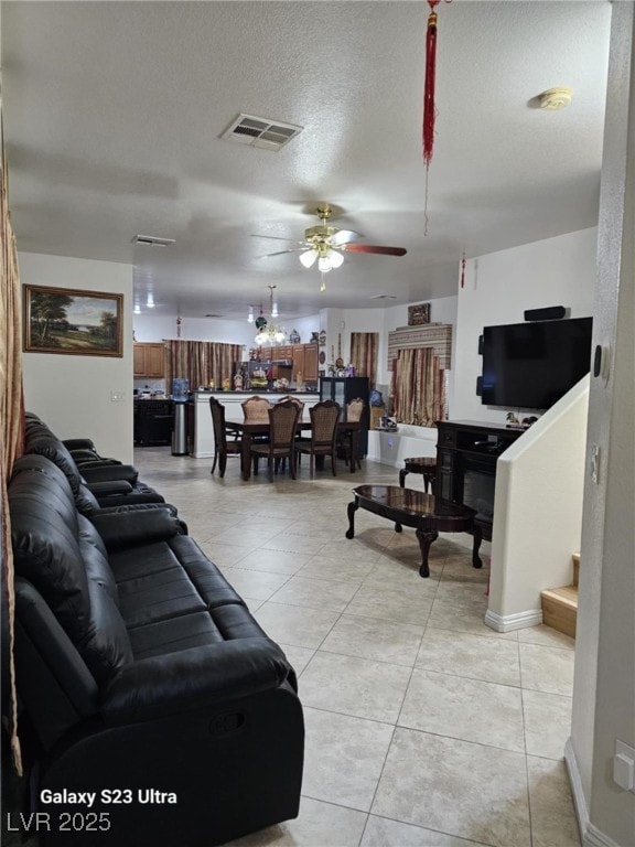 5651 Bettors Luck Ct, Las Vegas, NV 89122 - living area with a ceiling fan, light tile patterned floors, stairs, and a textured ceiling