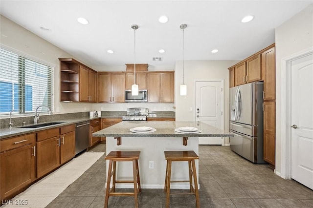 6713 Guidestar St, North Las Vegas, NV 89084 - kitchen with stainless steel appliances, a kitchen breakfast bar, a center island, brown cabinetry, and recessed lighting
