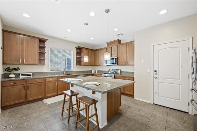 6713 Guidestar St, North Las Vegas, NV 89084 - kitchen featuring stainless steel appliances, open shelves, a kitchen island, light tile patterned flooring, and a breakfast bar area
