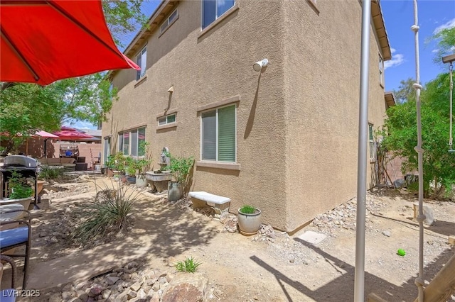 6713 Guidestar St, North Las Vegas, NV 89084 - view of side of home with stucco siding and a patio