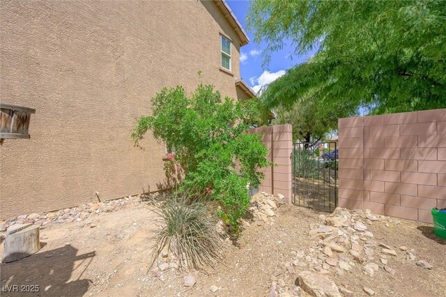 6713 Guidestar St, North Las Vegas, NV 89084 - view of home's exterior featuring stucco siding and a gate