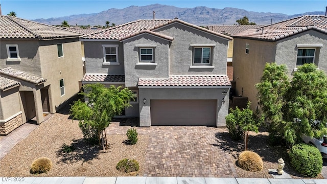 2024 Mystic Wave Rd, North Las Vegas, NV 89031 - mediterranean / spanish home featuring a tiled roof, stucco siding, an attached garage, and a mountain view