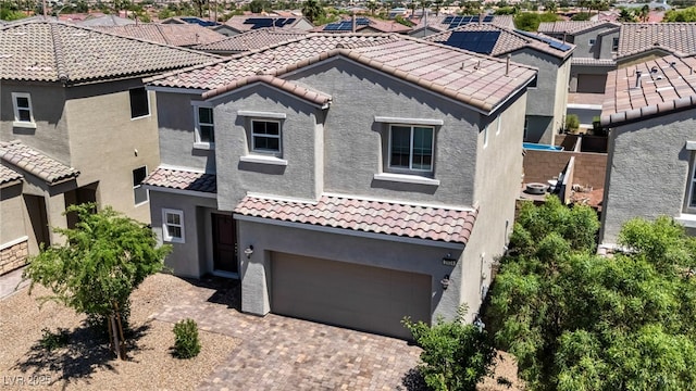 2024 Mystic Wave Rd, North Las Vegas, NV 89031 - mediterranean / spanish-style home featuring stucco siding, a garage, a tiled roof, a residential view, and decorative driveway