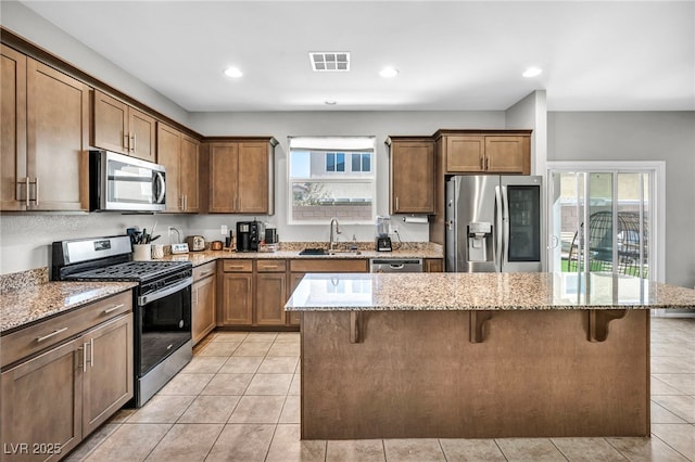 2024 Mystic Wave Rd, North Las Vegas, NV 89031 - kitchen with appliances with stainless steel finishes, a kitchen breakfast bar, light stone countertops, plenty of natural light, and recessed lighting
