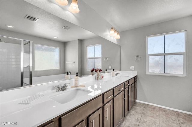 2024 Mystic Wave Rd, North Las Vegas, NV 89031 - bathroom with double vanity, tile patterned floors, a shower stall, and a textured ceiling