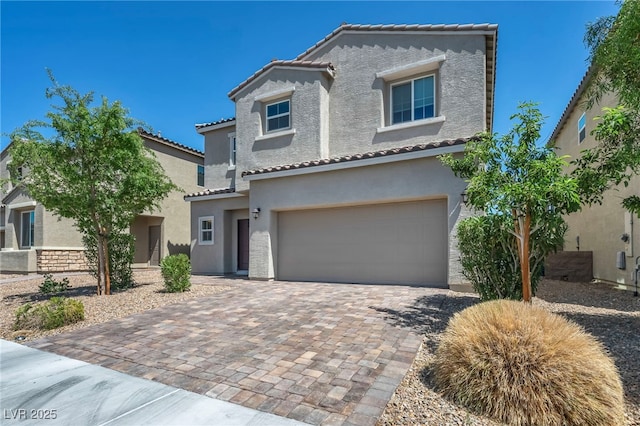 2024 Mystic Wave Rd, North Las Vegas, NV 89031 - view of front of house featuring stucco siding, an attached garage, a tiled roof, and decorative driveway